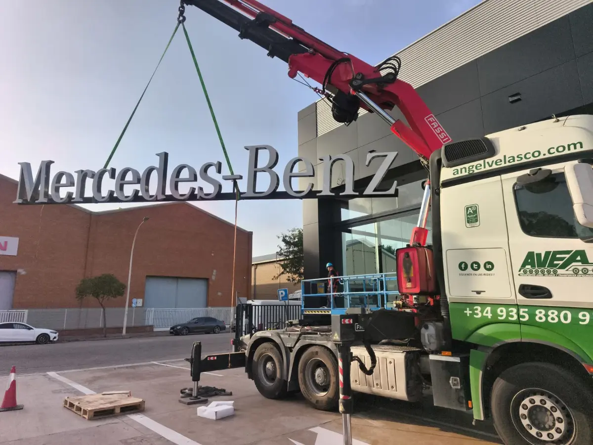 Izado de letras corpóreas Mercedes-Benz con camión grúa